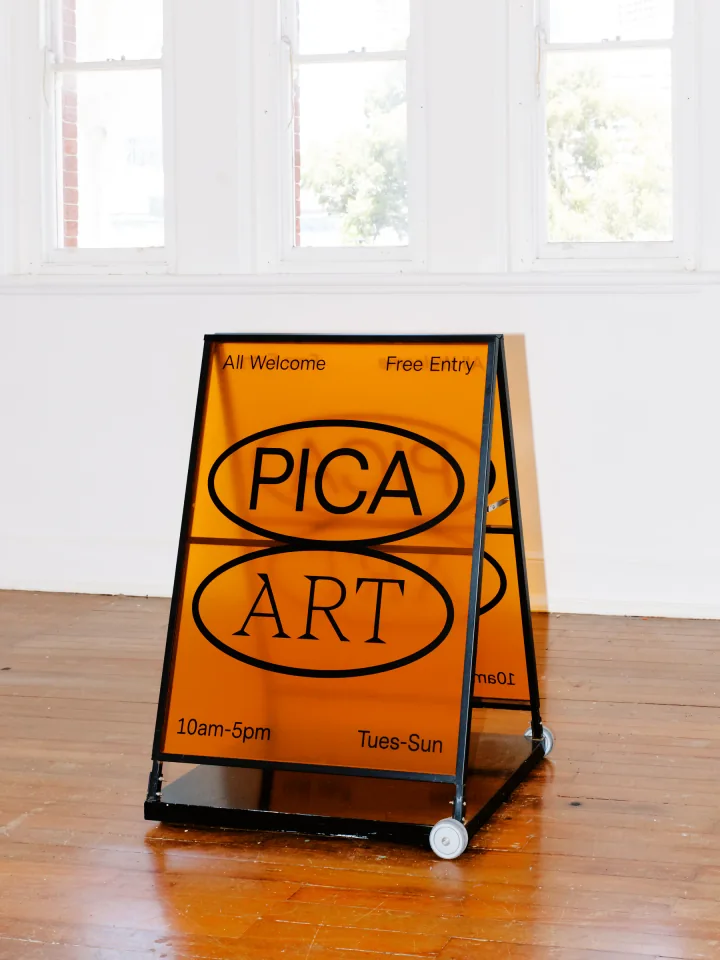 PICA’s orange Art A-frame sign in the gallery