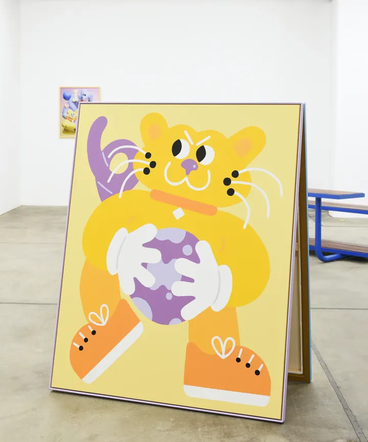 Yellow Sports Dreams character painting on an A-frame in the gallery