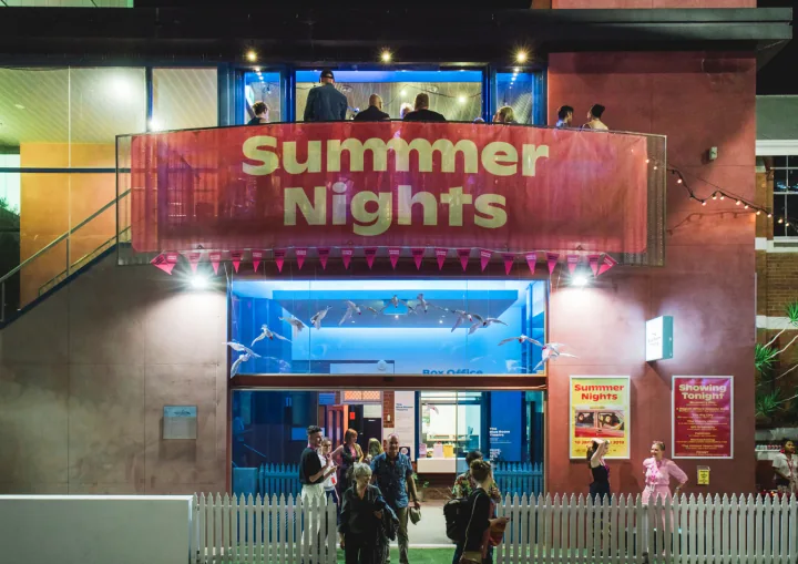 Summer Nights venue banner above the illuminated theatre entrance at night