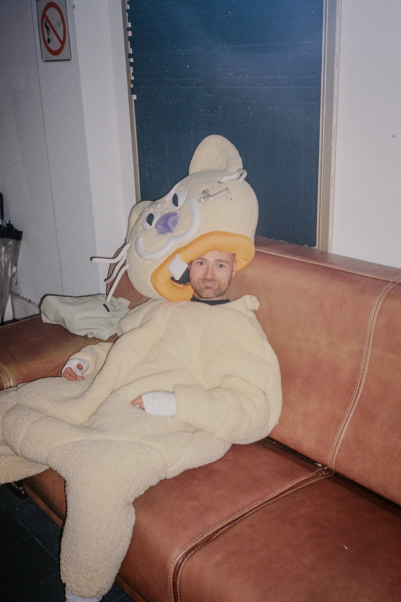Yellow Sports Dreams mascot sitting on a sofa during the production